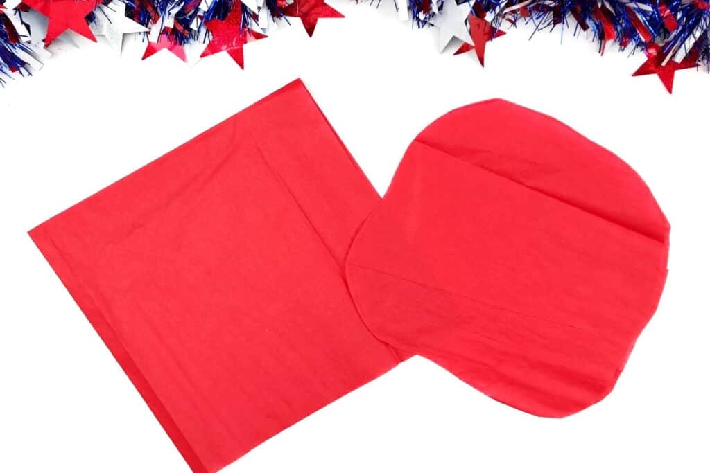 red tissue paper cut into square and circle for making paper poppy craft for kids