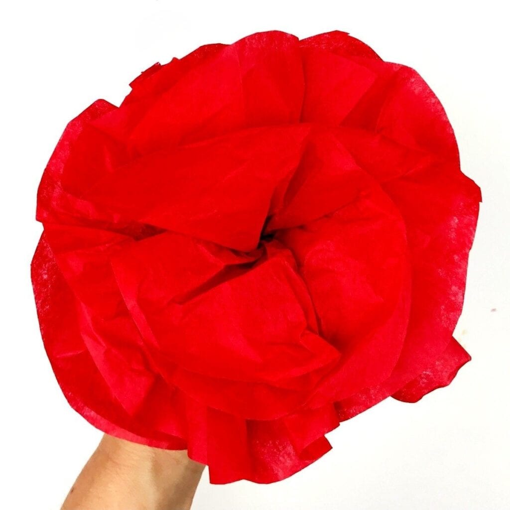 hand holding a red paper poppy flower craft for kids